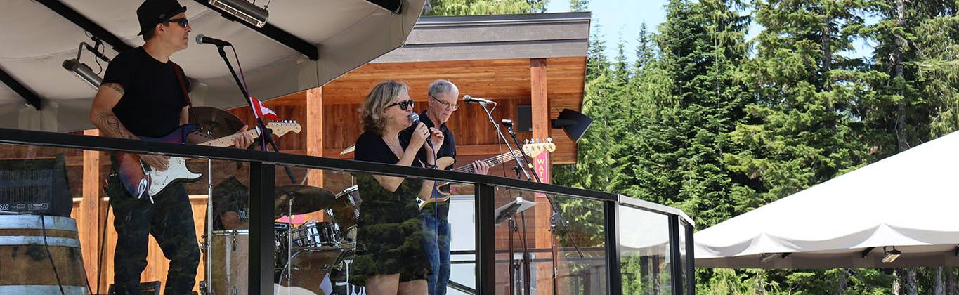 A band plays live music on top of a mountain patio.