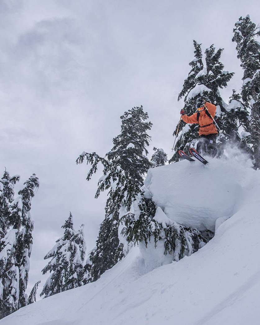 Skier performing a jump on a powder day.