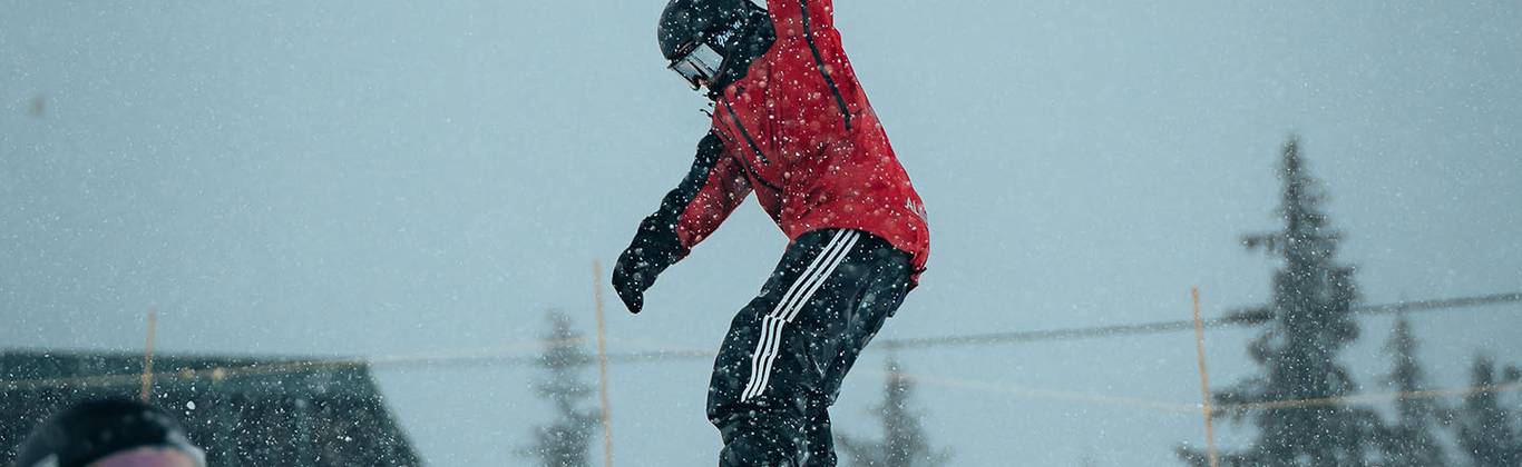 A snowboarder sliding on tube in terrain park.