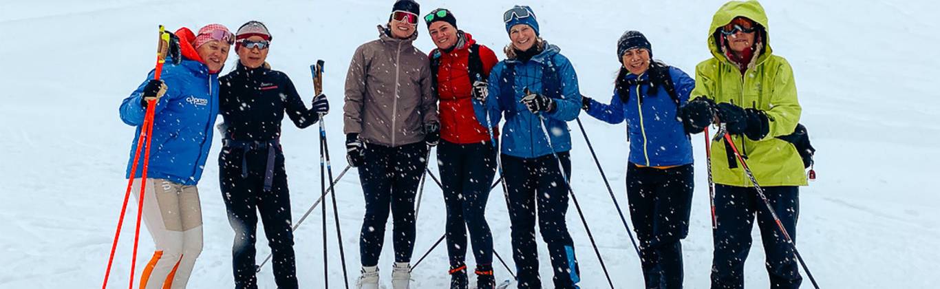 A group of women on cross country skis smile for a photo at Cypress Mountain's Nordic area