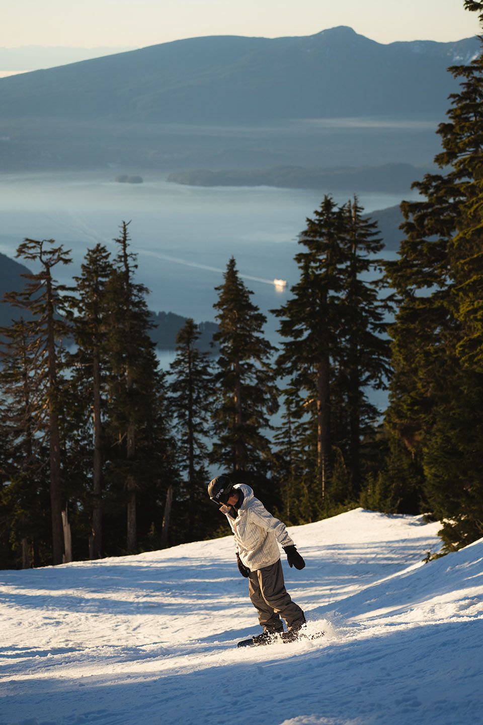 Snowboarder with island views in the background.