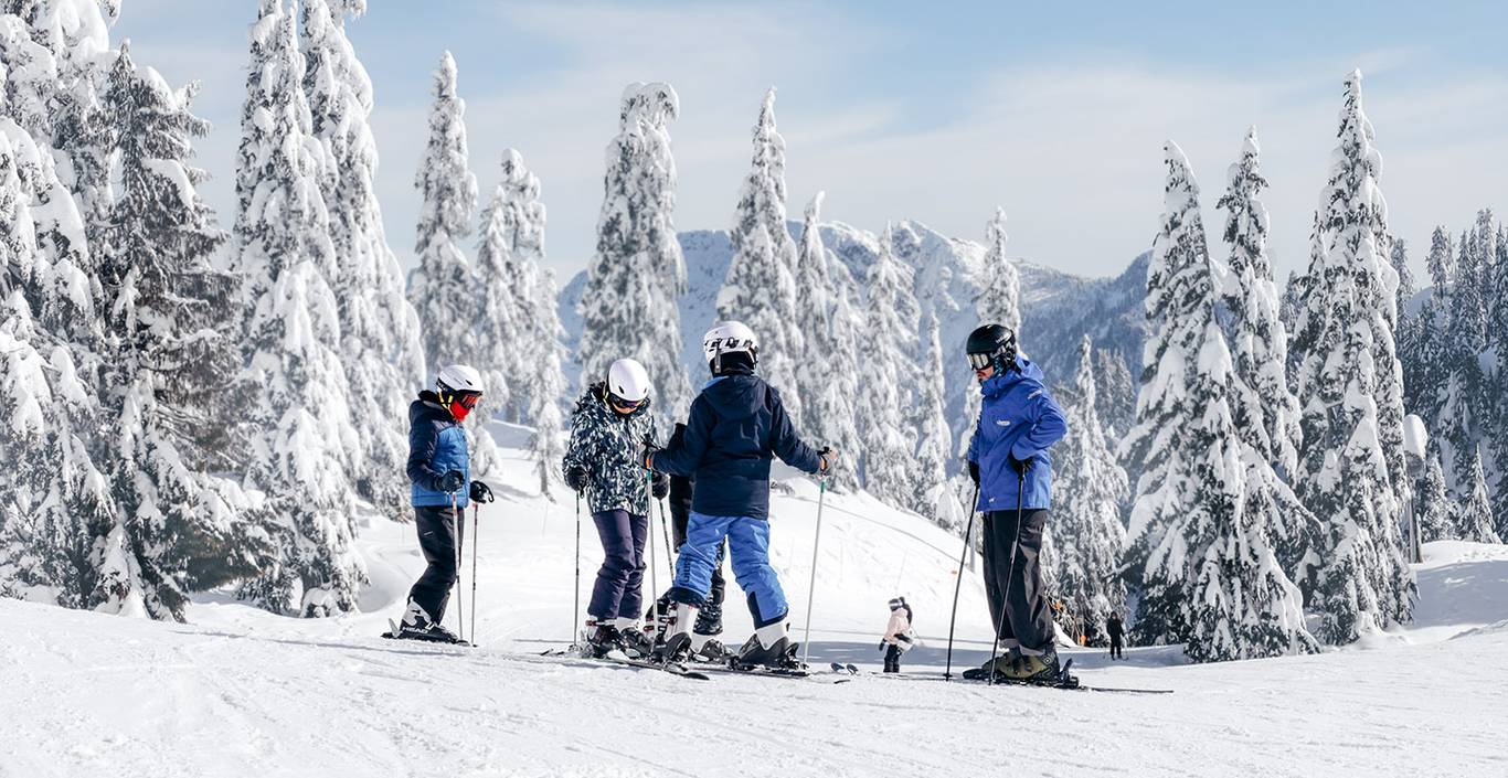 Ski instructor and youth students on snow.