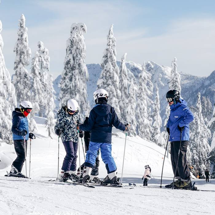 Ski instructor and youth students on snow.