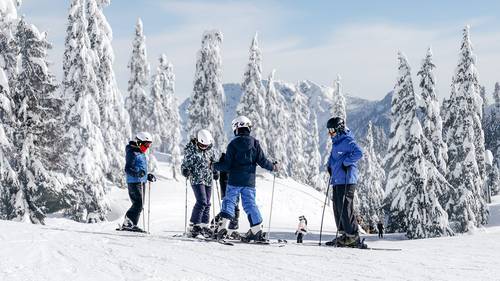 Ski instructor and youth students on snow.