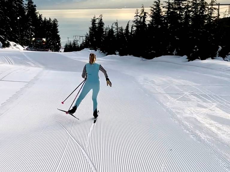 A woman cross country skiing during sunset