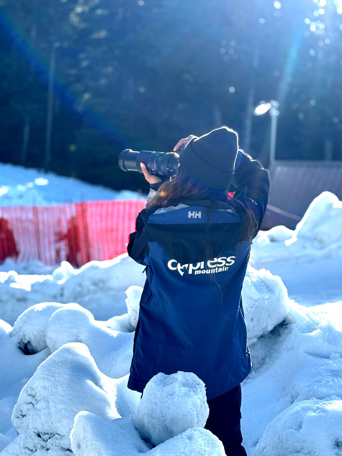 Marketing staff with a blue Cypress jacket taking pictures in snow.