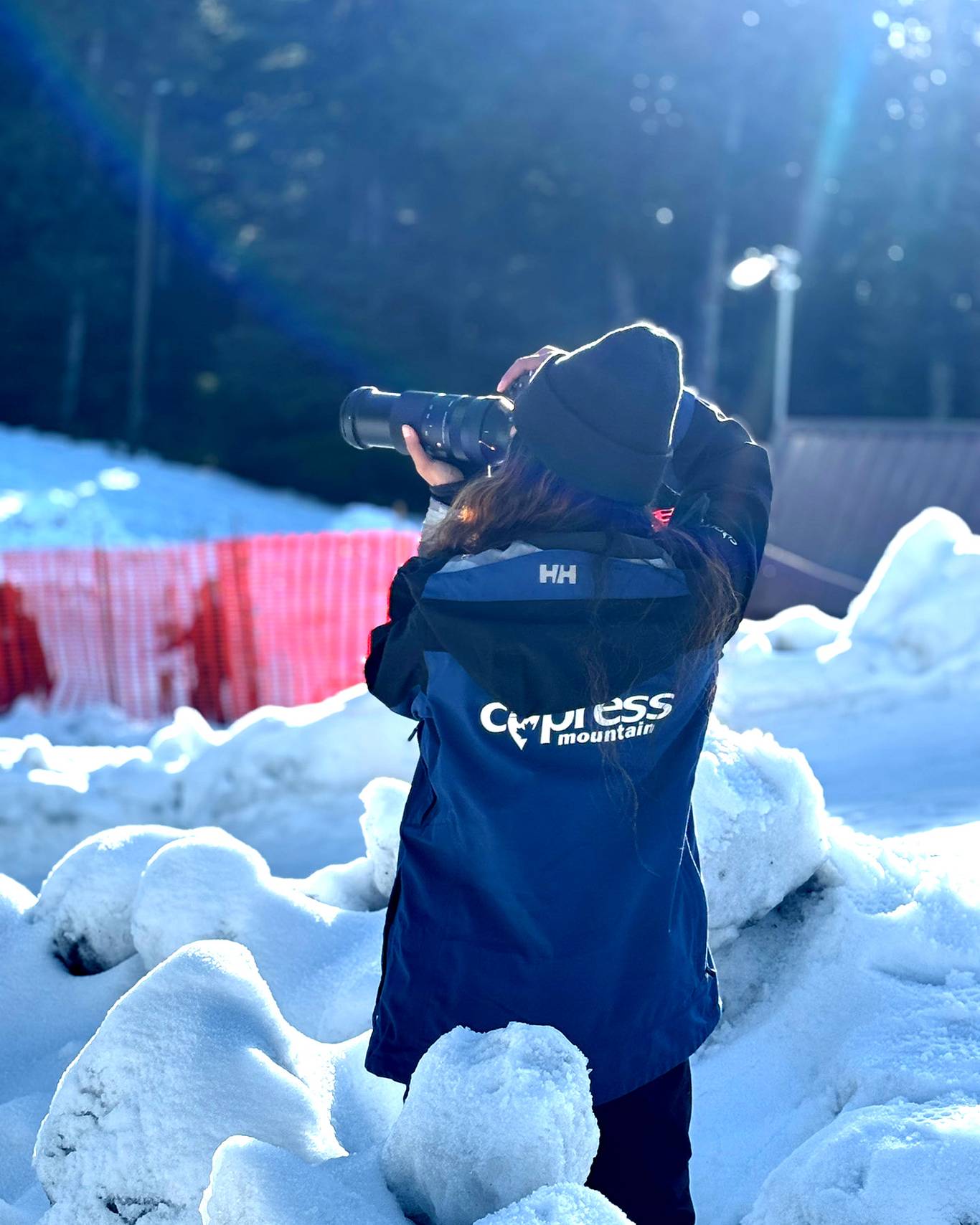 Marketing staff with a blue Cypress jacket taking pictures in snow.