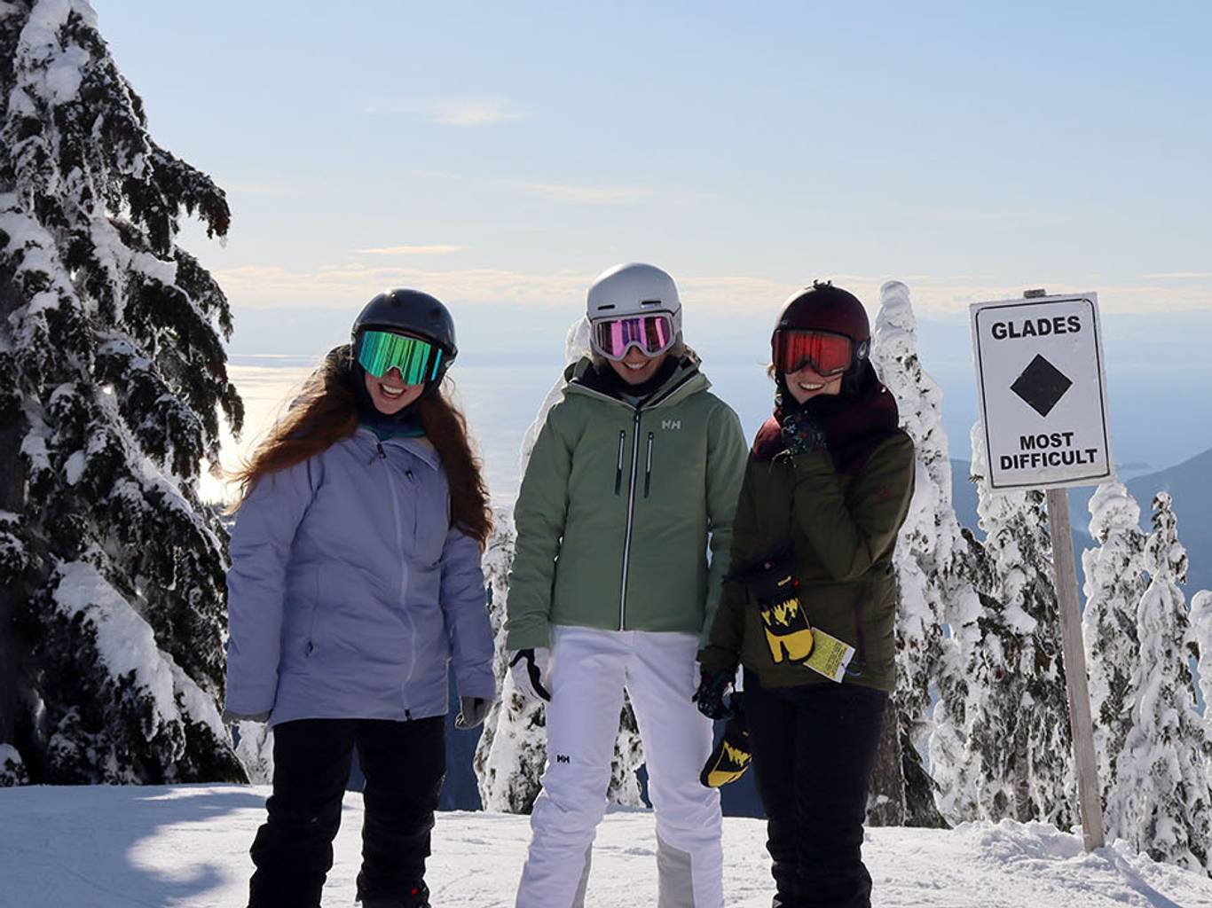Three women posing in front of the Glades run.
