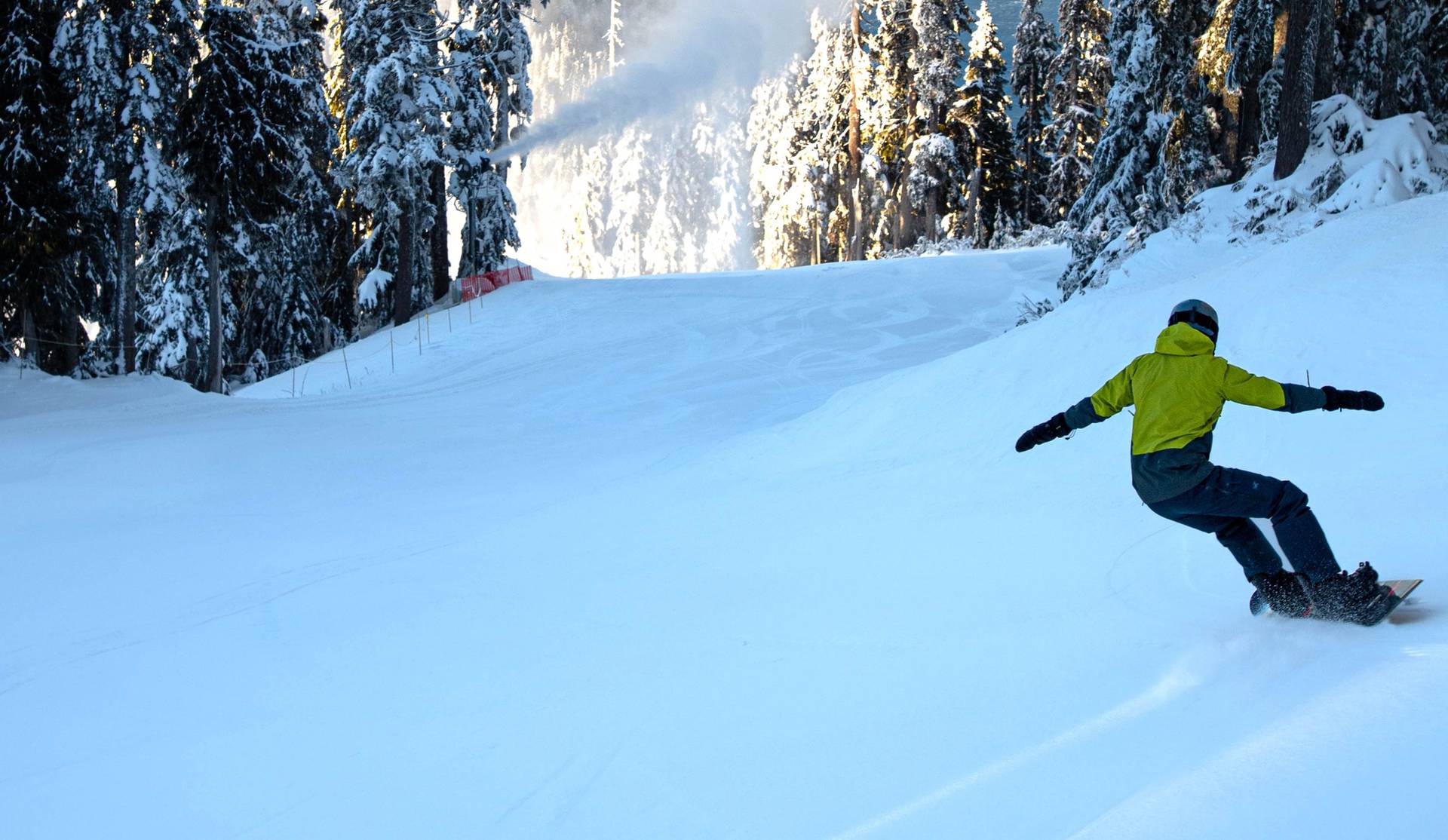 Snowboarder with a snowgun and ocean views in the background.