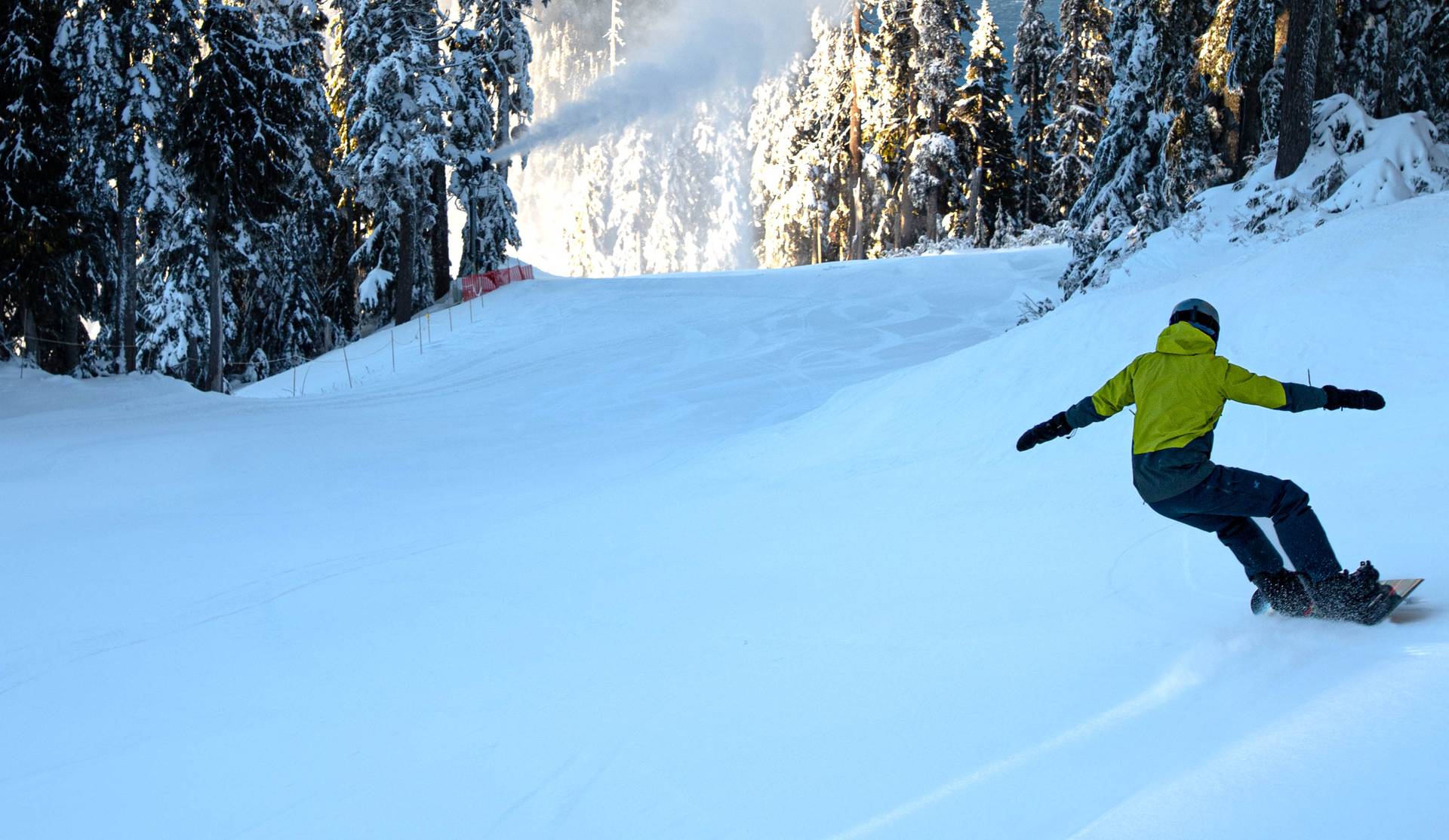 Snowboarder with a snowgun and ocean views in the background.
