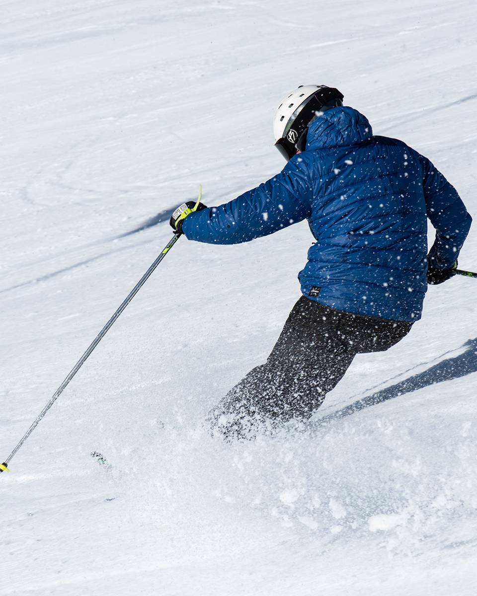 A person in blue jacket skiing.