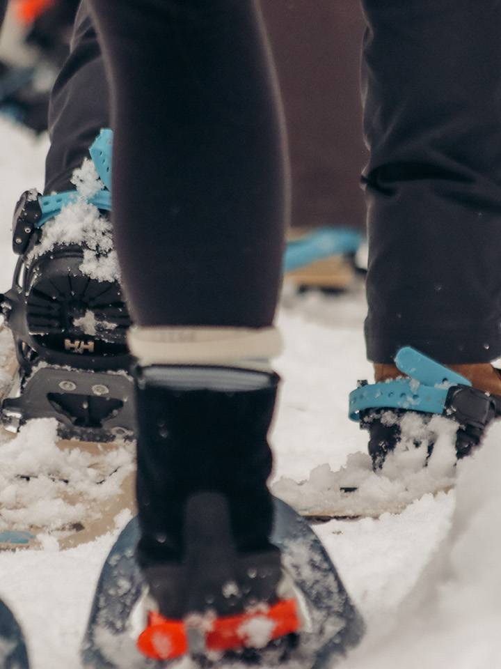 Closeup of people walking in snowshoes.