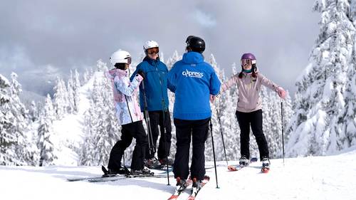 Ski instructor talking to a group of adult students