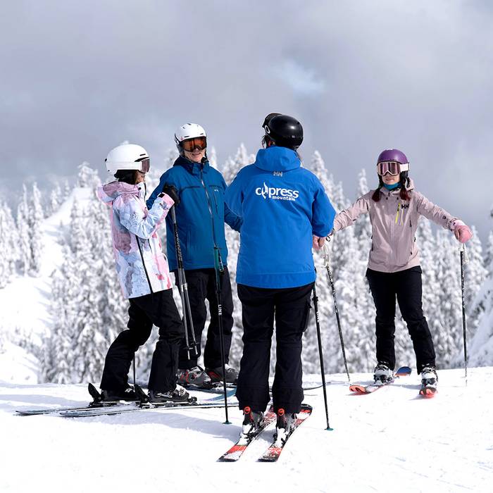 Ski instructor talking to a group of adult students