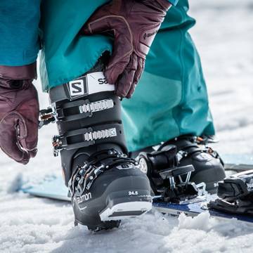 Person strapping their ski boots.