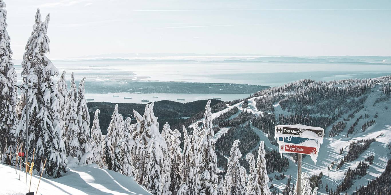 Ski run signs covered in snow on a bluebird day