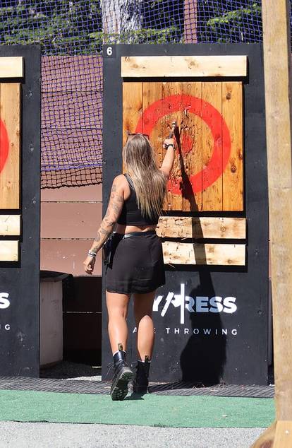 woman throwing axe on target