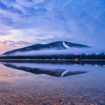 A ski hill as viewed from across a lake.