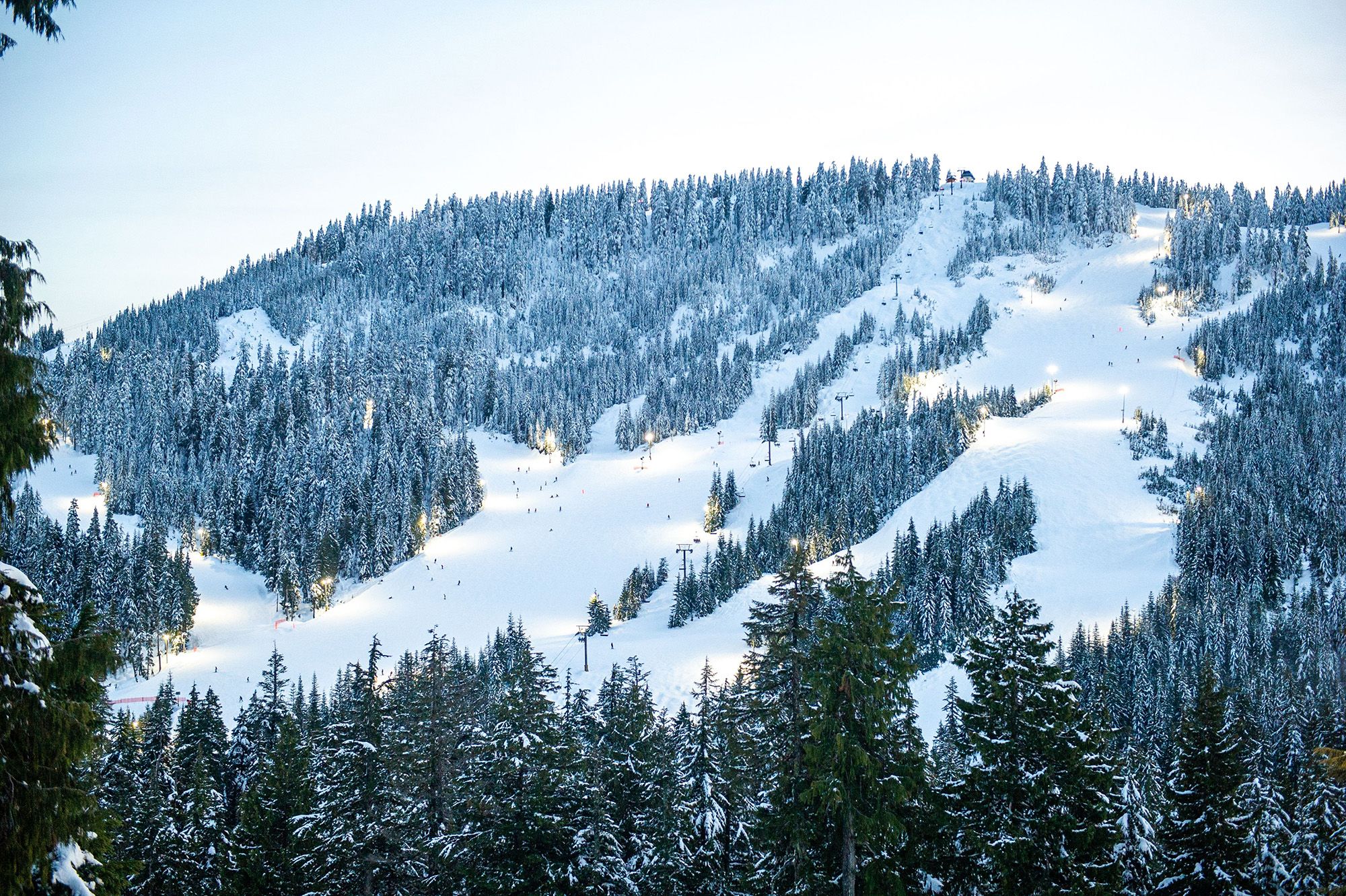 Ski runs are lit up by as night skiing begins at a ski resort.