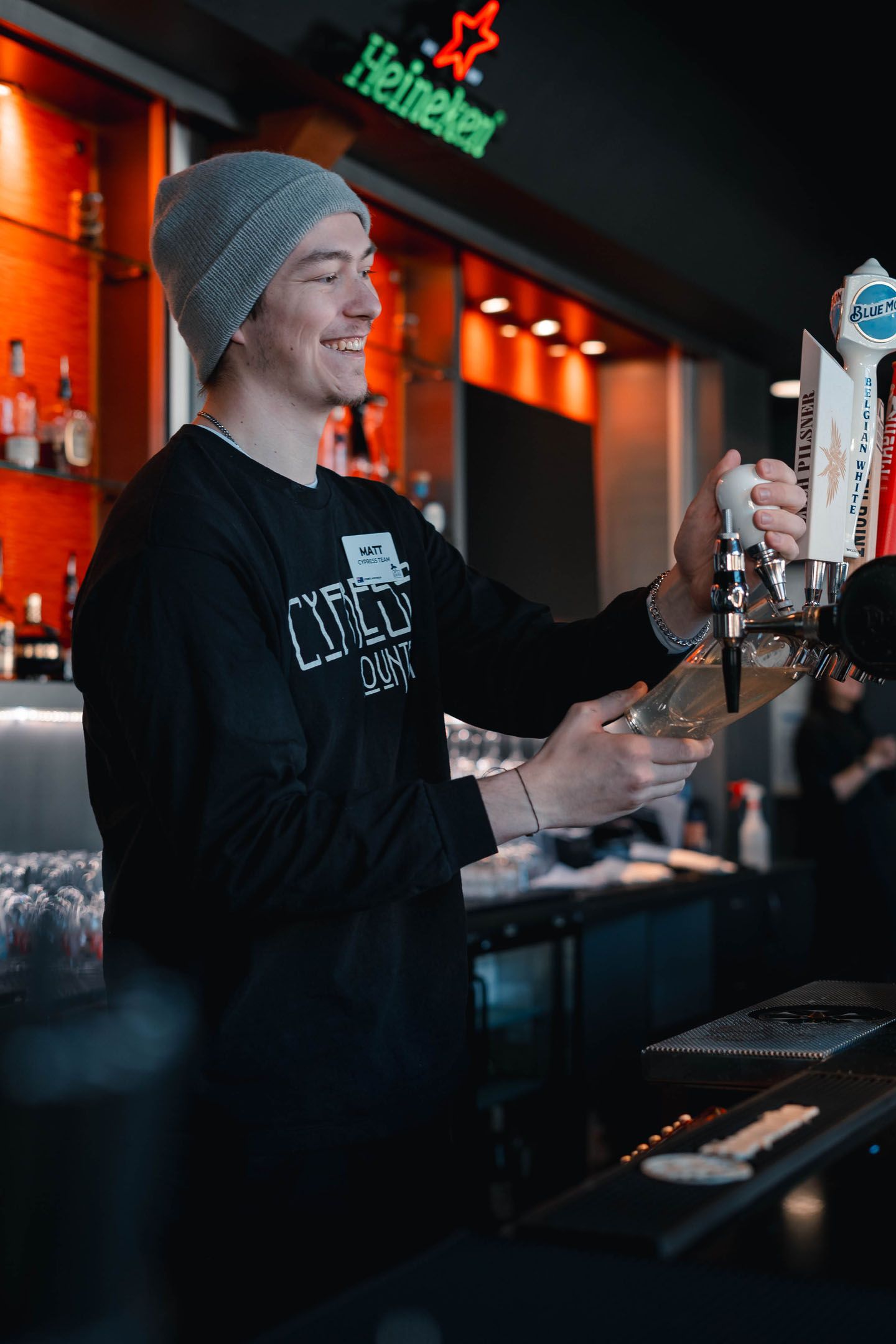 Bartender at Crazy Raven smiling and pouring beer.