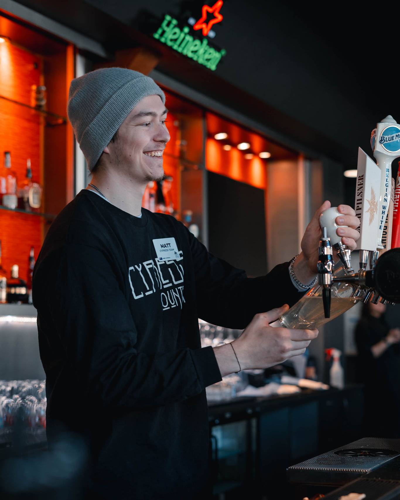 Bartender at Crazy Raven smiling and pouring beer.