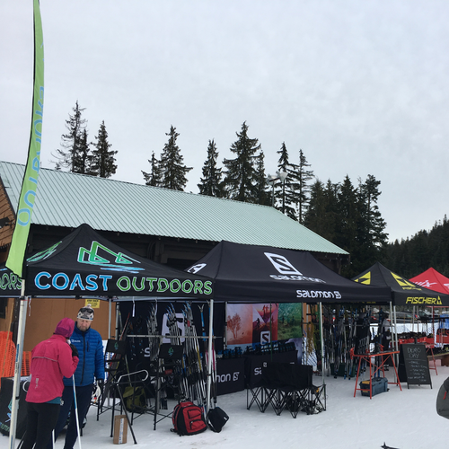 A lineup of branded tents outdoors demonstrating the latest cross country ski gear.
