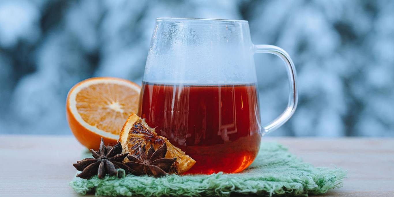 A warm tasty scented tea with orange sits with excellent presentation.