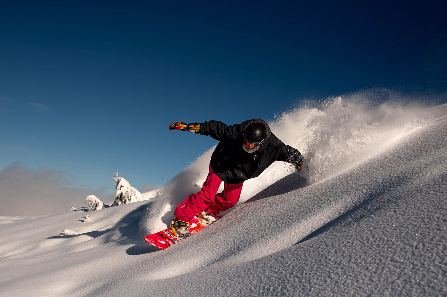 Snowboarder carving on powder