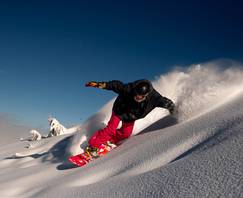 Snowboarder carving on powder