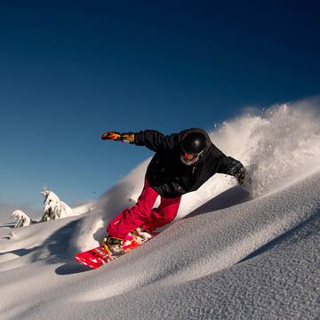 Snowboarder carving on powder