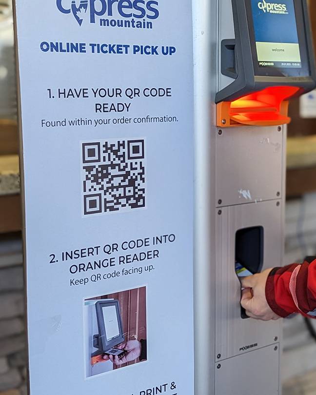Person getting their ticket from a kiosk.