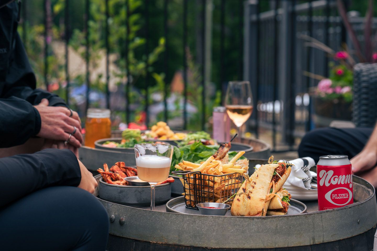 A plate of French fries served with a gourmet burger topped with fresh lettuce, tomato, and onion in a toasted bun, photographed in the cozy dining area of Crazy Raven Bar & Grill.