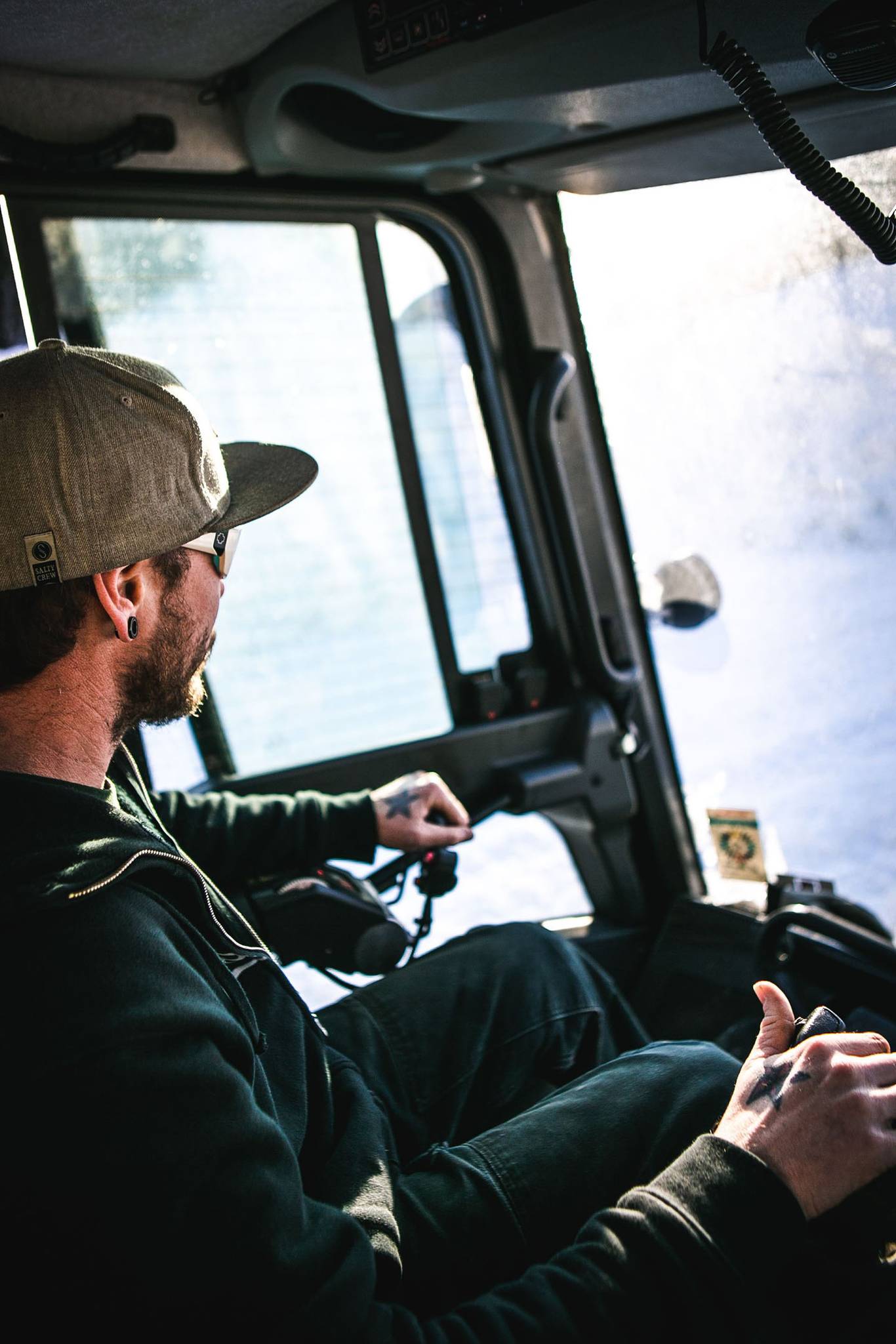 Snowcat operator driving in snow.