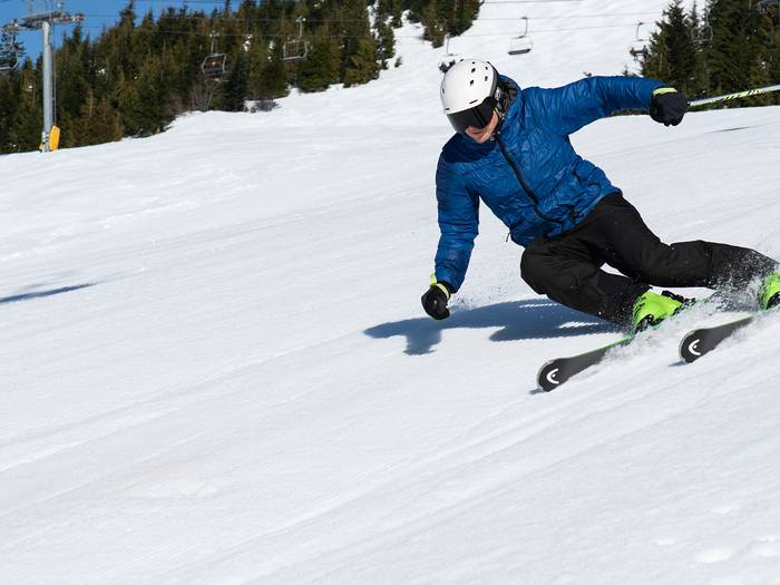 A man skiing down a hill on performance rental skis.