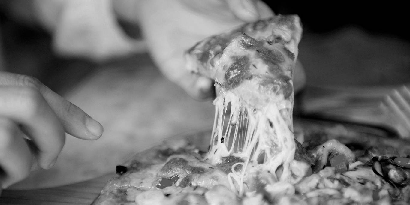 A slice of cheese pizza held by a customer.