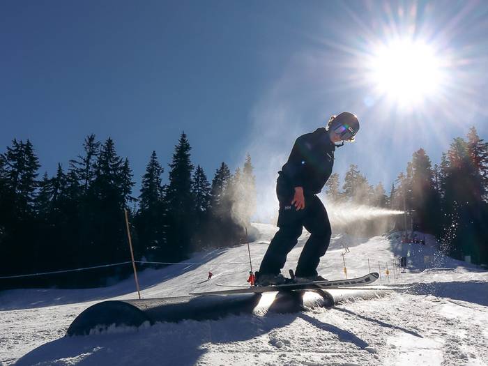Skier sliding on a tube on a sunny day.