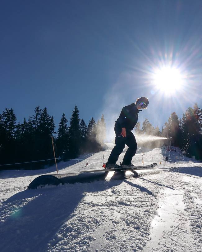Skier sliding on a tube on a sunny day.
