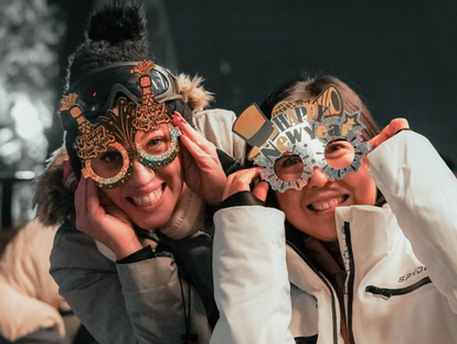 A crowd of people celebrate the New Year on the Cypress Mountain Patio.