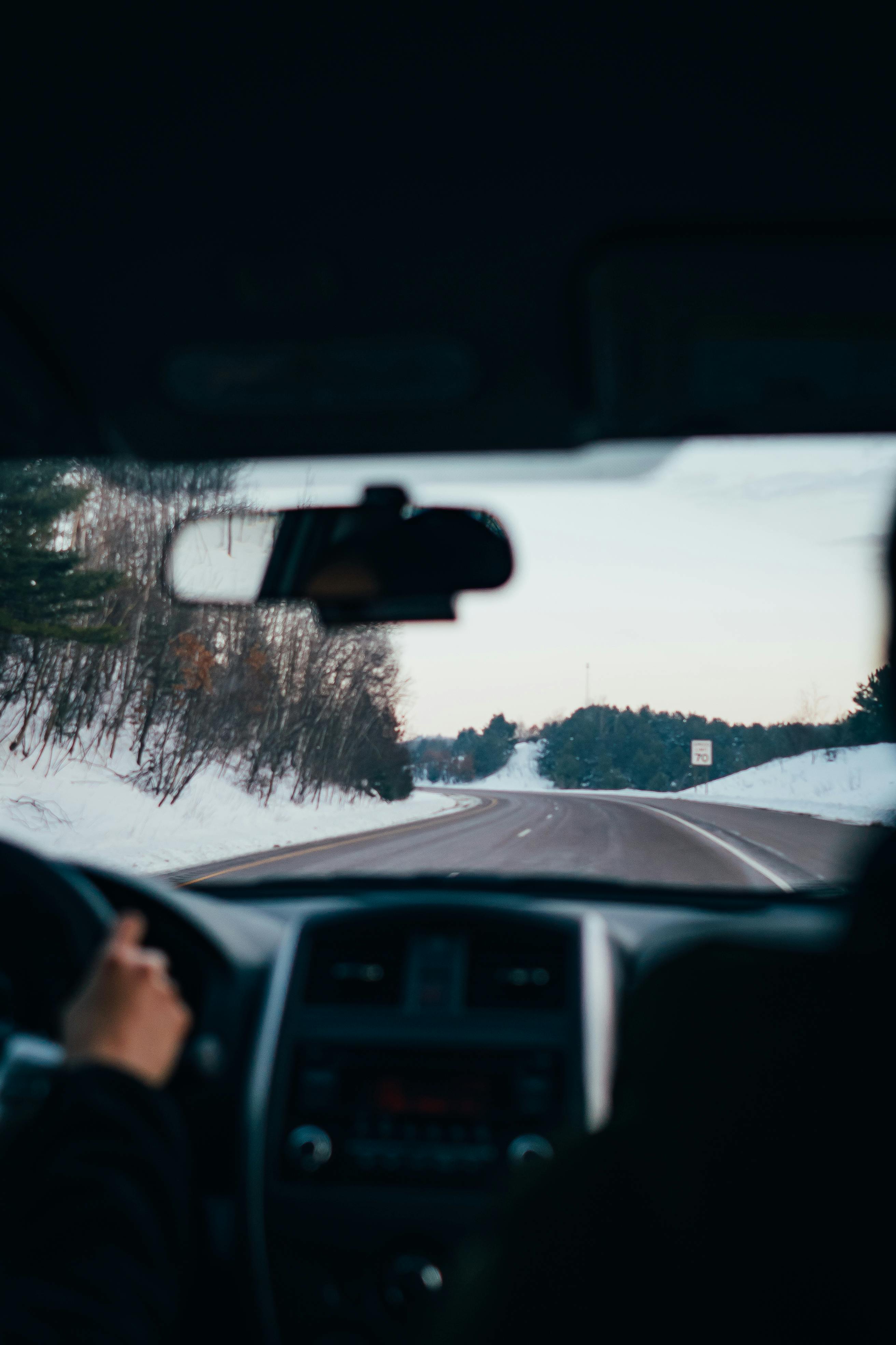View from inside a car driving through snowy road.