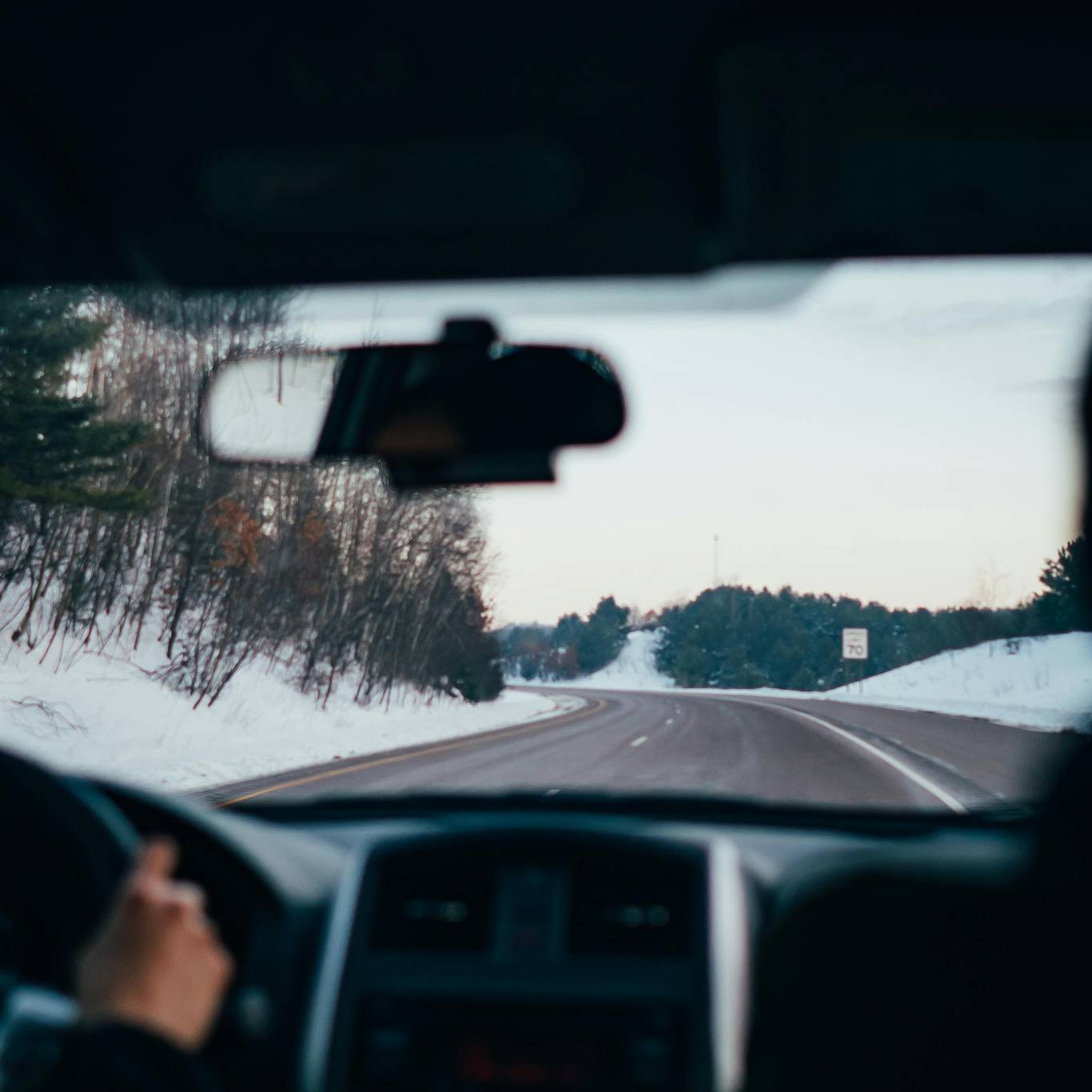 View from inside a car driving through snowy road.