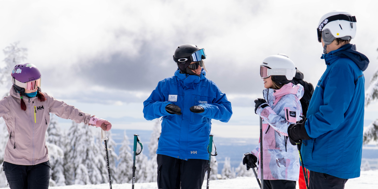 Instructor explains lesson plan to group of students on snowy mountain before descent.