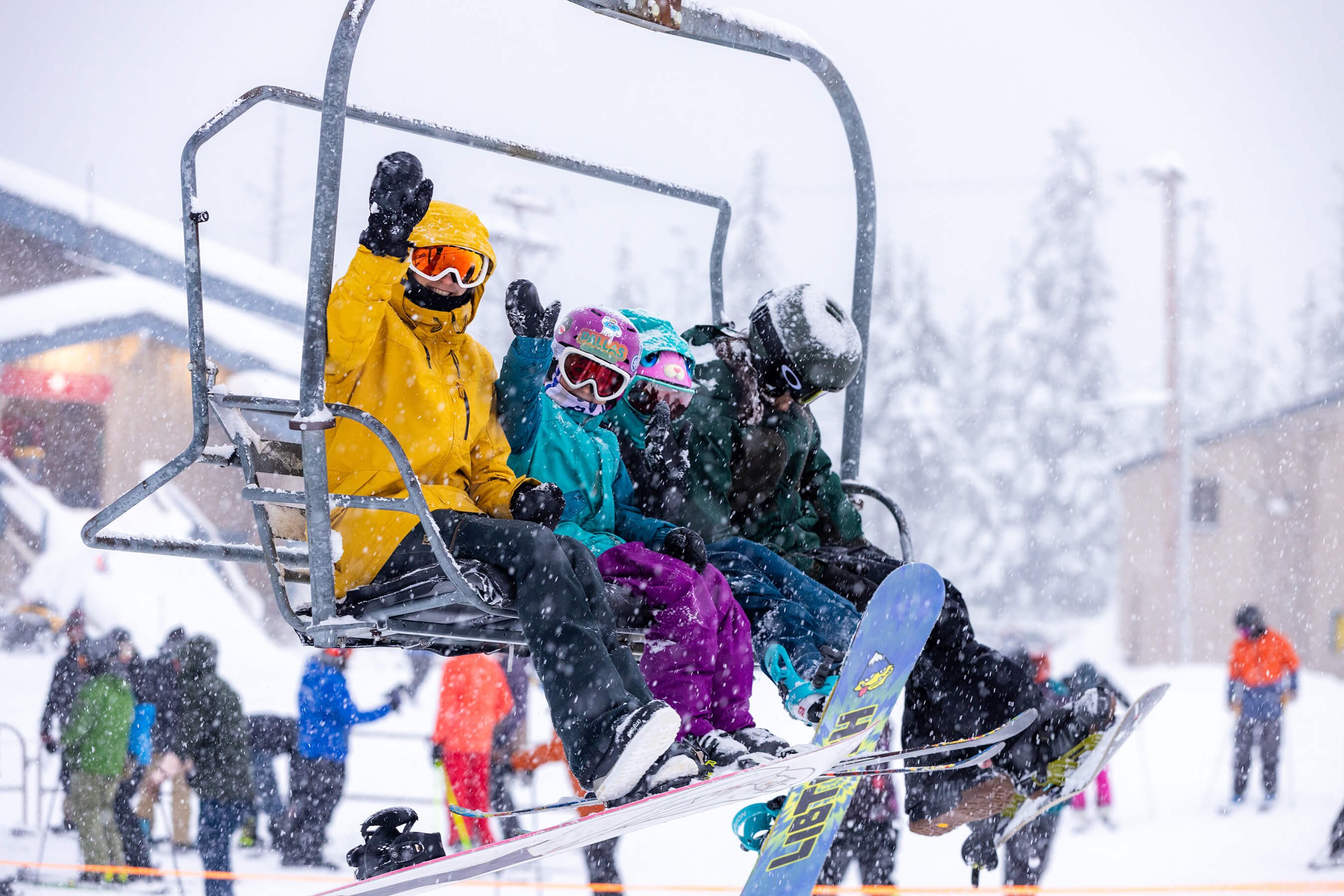 family on chairlift waving