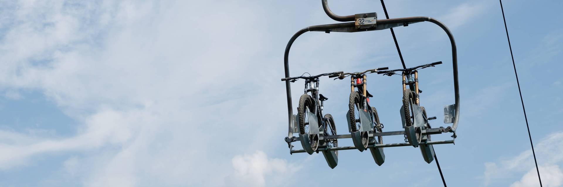 bikes on chairlift against blue skies