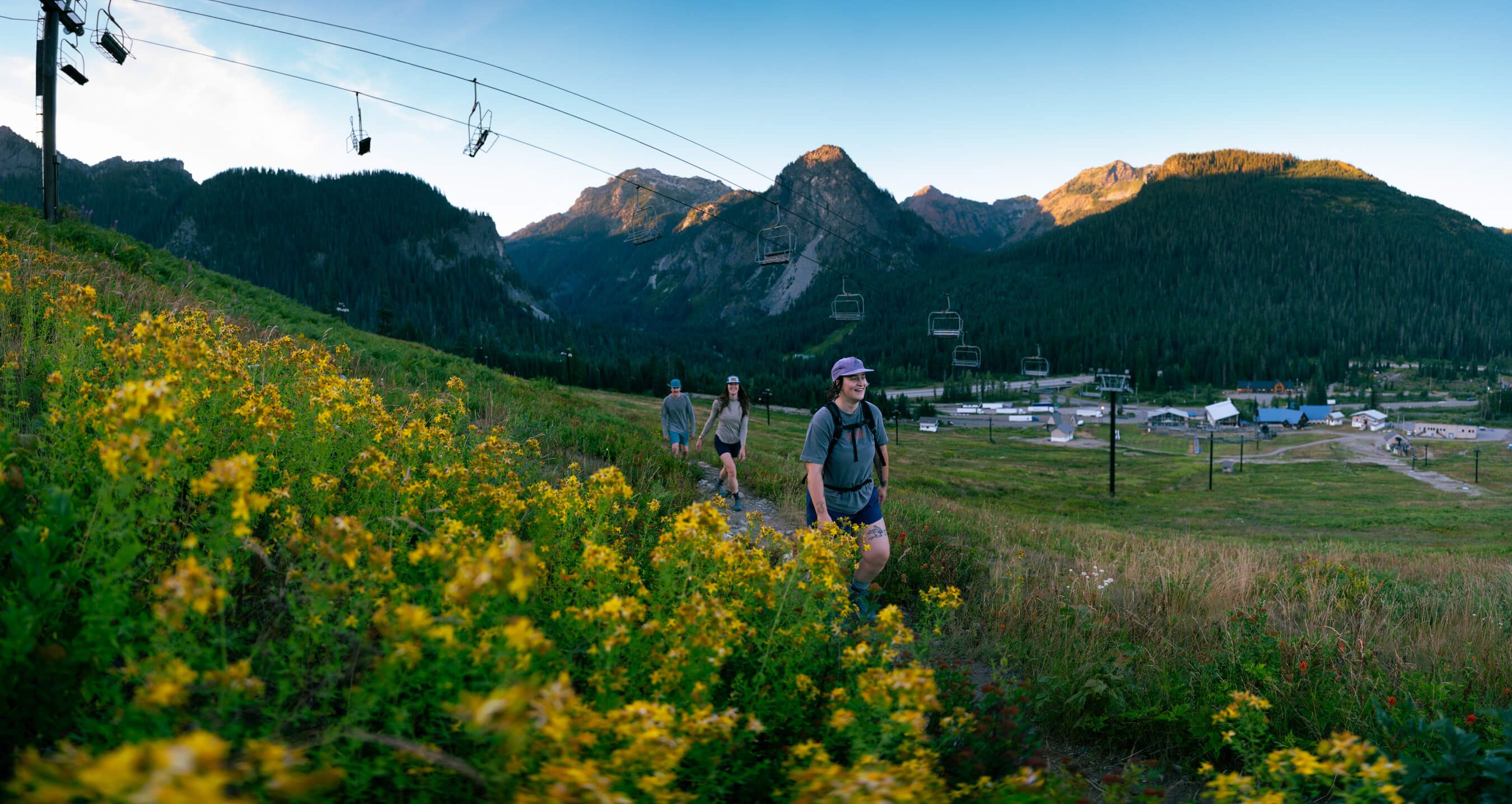 three hikers on the pacific crest trail walking under the pacific crest chairlift