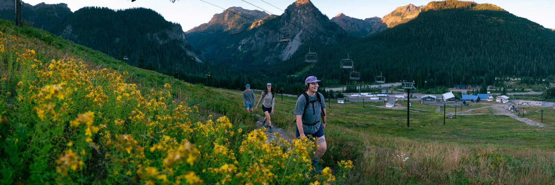 three hikers on the pacific crest trail walking under the pacific crest chairlift