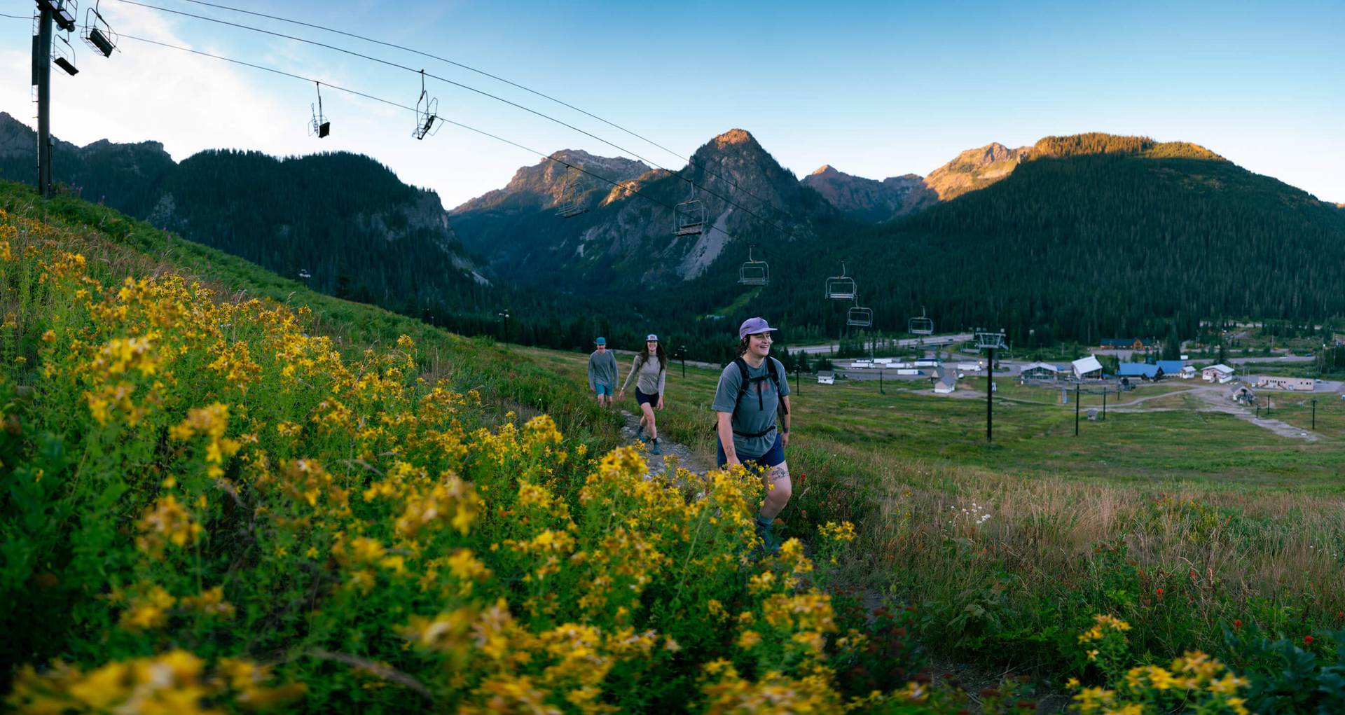 three hikers on the pacific crest trail walking under the pacific crest chairlift