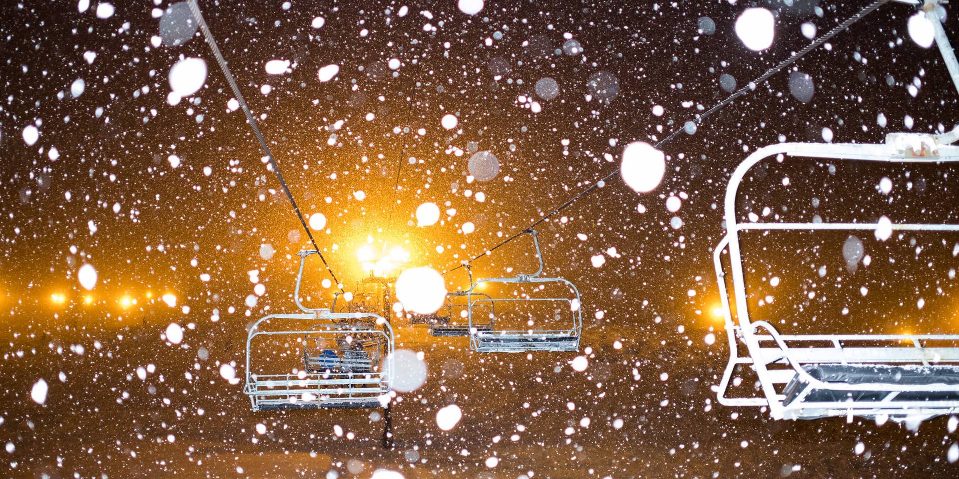 snowy image of chairlifts at night