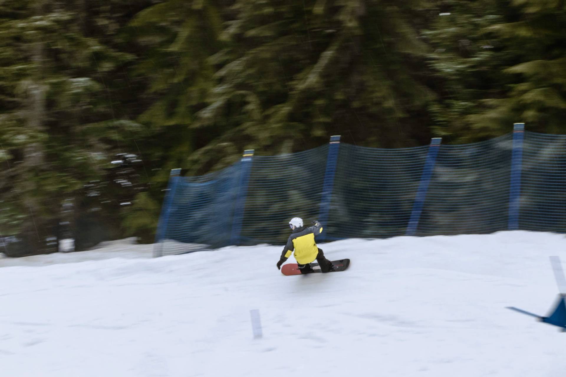 snowboarder moves quickly through banked slalom course