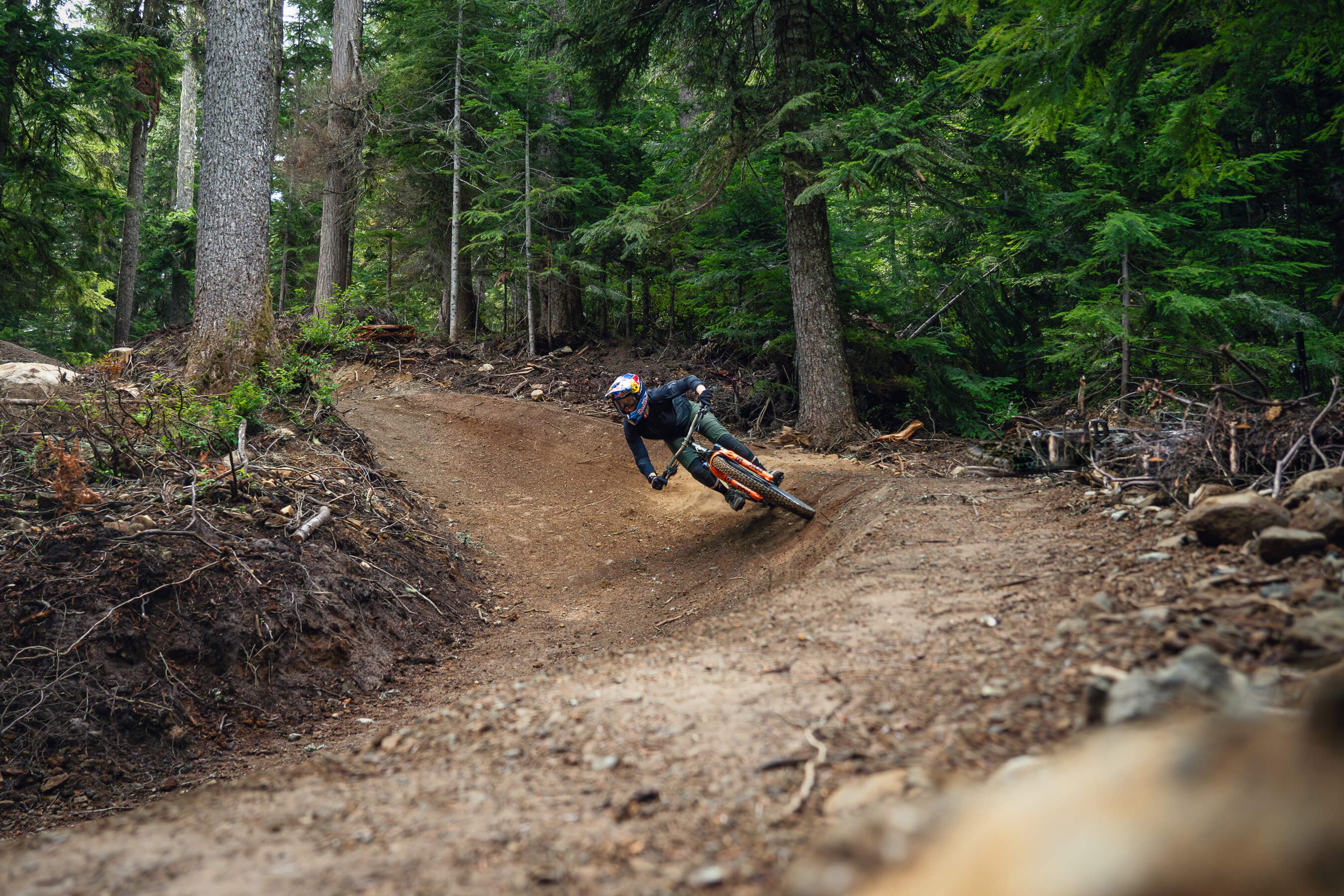 two riders on a berm in the trees