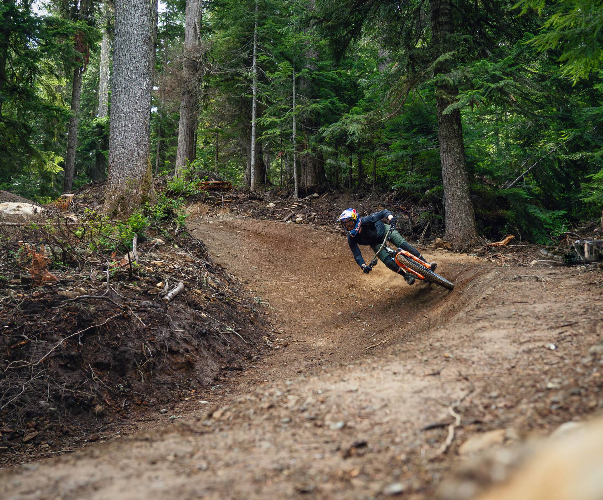 two riders on a berm in the trees